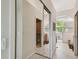 Hallway view showcasing a bathroom, hardwood floors, and natural light from an adjacent room at 3710 Rain Tree Ct, Palm Harbor, FL 34685