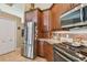 Kitchen with stainless steel refrigerator and appliances, stone backsplash and wood cabinets at 3710 Rain Tree Ct, Palm Harbor, FL 34685