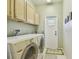 Laundry room with washer, dryer, cabinets, and exterior access at 3710 Rain Tree Ct, Palm Harbor, FL 34685