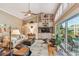 Spacious living room with a high ceiling, built-in shelving, and sliding doors to the pool area at 3710 Rain Tree Ct, Palm Harbor, FL 34685