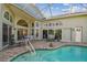 Enclosed pool and patio area with seating and dining furniture at 3710 Rain Tree Ct, Palm Harbor, FL 34685