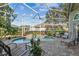 Screened-in patio with poolside chairs surrounding a pool and jacuzzi at 3710 Rain Tree Ct, Palm Harbor, FL 34685