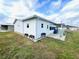 Back view of property featuring vinyl siding, a patio, and green grass at 37544 Corey Lewis Ave, Zephyrhills, FL 33541