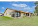 Backyard view of a home with a screened porch and grassy area at 38351 Ironwood Pl, Zephyrhills, FL 33542