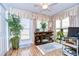 Bright sunroom featuring a fireplace, built-in shelving and hardwood floors at 38351 Ironwood Pl, Zephyrhills, FL 33542