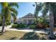 Tan house with palm trees and a well-manicured lawn, inviting curb appeal at 404 Manns Harbor Dr, Apollo Beach, FL 33572