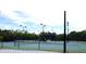 Two lighted tennis courts with a shaded seating area at 404 Manns Harbor Dr, Apollo Beach, FL 33572