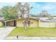 Ranch home with a tree and a fenced yard at 4513 W Clifton St, Tampa, FL 33614