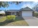 Brick ranch home with attached garage and manicured lawn at 4804 Foxshire Cir, Tampa, FL 33624