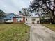 Brick ranch house with a yard, driveway, and trees at 4865 163Rd N Ave, Clearwater, FL 33762