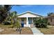 Charming bungalow with a light blue front door, front porch, and landscaped yard at 502 E Cluster Ave, Tampa, FL 33604