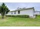 View of the home's side with neatly trimmed hedges at 6125 Alpine Dr, Zephyrhills, FL 33542