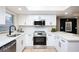 Modern kitchen featuring white shaker cabinets, quartz countertops, and stainless steel appliances at 6411 Monterey Blvd, Tampa, FL 33625