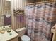 Clean bathroom with striped shower curtain and updated vanity at 6428 Remus Dr, New Port Richey, FL 34653