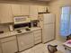 Kitchen with white cabinets, refrigerator, and microwave at 6428 Remus Dr, New Port Richey, FL 34653