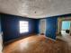 A bedroom with blue walls, hardwood floors, and a doorway to a small bathroom at 6502 S Himes Ave, Tampa, FL 33611