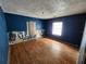 A bedroom with blue walls and damaged wooden floors at 6502 S Himes Ave, Tampa, FL 33611