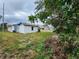 Rear view of a small house needing repairs, with overgrown yard at 6502 S Himes Ave, Tampa, FL 33611