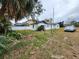 Exterior view of a small house with overgrown yard at 6502 S Himes Ave, Tampa, FL 33611