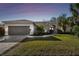 House exterior at dusk, showcasing landscaping and garage at 714 Hidden Lake Dr, Tarpon Springs, FL 34689