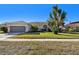 House exterior showcasing landscaping and garage at 714 Hidden Lake Dr, Tarpon Springs, FL 34689