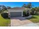 House exterior with a gray garage door and brick driveway at 714 Hidden Lake Dr, Tarpon Springs, FL 34689