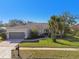 House exterior with a gray garage door and mailbox at 714 Hidden Lake Dr, Tarpon Springs, FL 34689