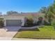 Exterior view of a single-Gathering home with a gray garage door at 714 Hidden Lake Dr, Tarpon Springs, FL 34689