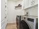 Laundry room with LG washer and dryer, upper cabinets, and wood-look flooring at 714 Hidden Lake Dr, Tarpon Springs, FL 34689