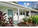 Inviting home entryway featuring a charming teal door, lush plants, and decorative accents at 731 74Th N St, St Petersburg, FL 33710