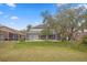 Spacious backyard featuring a screened-in lanai and lush green lawn, perfect for outdoor relaxation at 8619 Foxtail Ct, Tampa, FL 33647