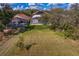 Aerial shot of a home with a screened-in pool and spacious grassy backyard with mature trees at 8619 Foxtail Ct, Tampa, FL 33647