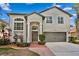 Two-story home with an attached two-car garage, arched windows, and a brick-lined walkway at 8619 Foxtail Ct, Tampa, FL 33647