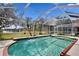 In-ground pool with screened enclosure showcases water views of a beautiful, well-maintained backyard and lawn at 8619 Foxtail Ct, Tampa, FL 33647