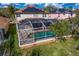 Aerial view of a screened-in pool area surrounded by lush landscaping, offering a private oasis at 8619 Foxtail Ct, Tampa, FL 33647