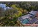 Aerial view of a sparkling pool with a screened enclosure, solar panels and scenic backyard at 8619 Foxtail Ct, Tampa, FL 33647