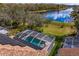 Aerial view showcasing solar panels with backyard pool and landscaped with mature trees at 8619 Foxtail Ct, Tampa, FL 33647