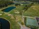 Aerial view of Seven Springs Golf Course with ponds and tennis courts at 9204 Golf View Dr, New Port Richey, FL 34655