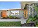 Front entrance with a modern wood door and geometric concrete block detail at 9893 111Th St, Seminole, FL 33772