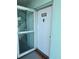 Condo entry with white door, numbered 210, and a storm door at 1819 Shore S Dr # 210, South Pasadena, FL 33707