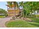 Two-story home with a yellow exterior and palm trees at 1011 Sonata Ln, Apollo Beach, FL 33572