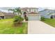 Two-story house with light gray siding, red door, and a large driveway at 11601 Mansfield Point Dr, Riverview, FL 33569