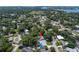 Aerial view of a home featuring a swimming pool, surrounded by mature trees and neighborhood residences at 1201 77Th N St, St Petersburg, FL 33710