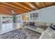 Cozy living room with exposed wood ceiling, light-colored walls, comfortable seating and large windows at 1201 77Th N St, St Petersburg, FL 33710