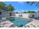 Backyard pool featuring a lounge area with chairs and an umbrella for relaxation at 1201 77Th N St, St Petersburg, FL 33710