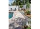 Lounge area next to the pool with well-kept landscaping, black chairs and a large brick paved area at 1201 77Th N St, St Petersburg, FL 33710