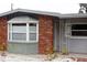 Partial view of brick and gray exterior, featuring a bay window and entrance at 12361 114Th St, Largo, FL 33778