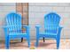 Two blue plastic chairs sit on a patio next to a brick wall at 12361 114Th St, Largo, FL 33778