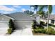 Two-story house with gray exterior, two-car garage, and palm trees at 1252 Lyndhurst Greens Dr, Sun City Center, FL 33573