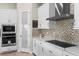 Close up of a bright kitchen featuring modern appliances and mosaic backsplash and white cabinets at 13182 Twin Bridges Dr, Riverview, FL 33579